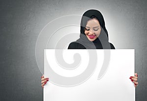 Arabian business woman holding a white board isolated