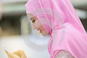 Arabian business woman smiling happy to use cell phone and modern business city background