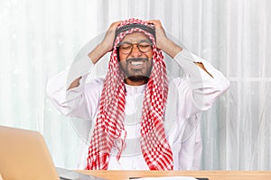 Arabian businessman feeling disappoint and suffer about his business in the office photo