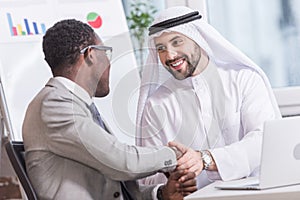 Arabian businessman shaking hands with african american partner