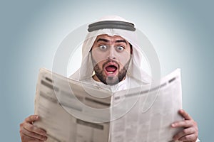 Arabian businessman shocked while reading newspape