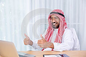 Arabian businessman smile and happy from message his computer notebook in his office