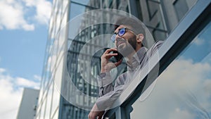 Arabian businessman talk phone mobile call in city bottom view sky reflection outdoors Indian man entrepreneur talking