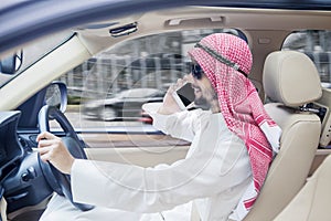 Arabian businessman talking on a phone in car
