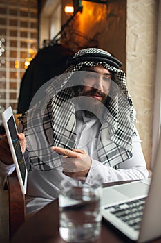 Arabian businessman working in office, business centre using devicesm gadgets. Lifestyle
