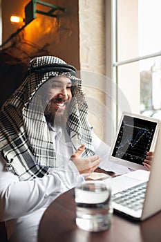 Arabian businessman working in office, business centre using devicesm gadgets. Lifestyle