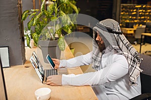 Arabian businessman working in office, business centre using devicesm gadgets. Lifestyle