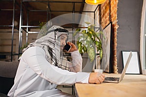 Arabian businessman working in office, business centre using devicesm gadgets. Lifestyle