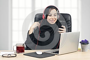 Arabian Businesswoman listening to music in the office