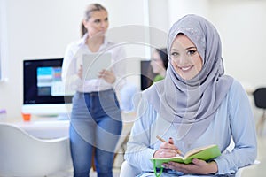 Arabian Businesswoman in startup office with team working in the background, photo