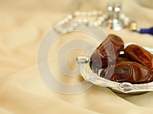 Arabian dates with pearl beads masbah and perfume bokeh