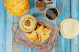 Arabian dinner table with pita bread, hummus and olives