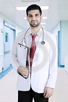 Arabian doctor with clipboard in the hospital