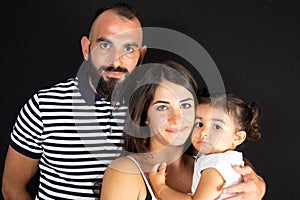 Arabian family portrait in studio black background father mother and son posing together