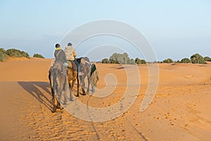 The arabian guide with couple of tourist in Sahara desert