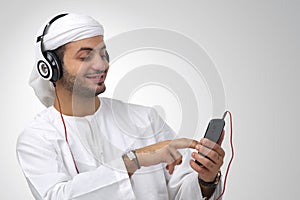 Arabian guy listening to music using headphones isolated