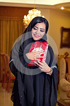 Arabian lady wearing hijab receiving a gift