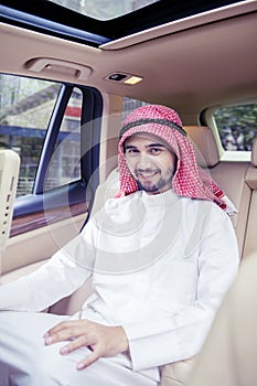 Arabian man smiling at the camera inside car