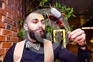 arabian man sommelier appreciating drink in lux hotel