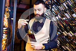 arabian man sommelier appreciating drink in lux hotel