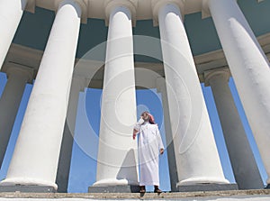 Arabian man standing in front of large columns