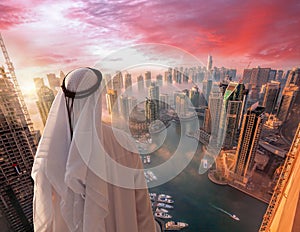 Arabian man is watching Dubai marina in Dubai, United Arab Emirates.