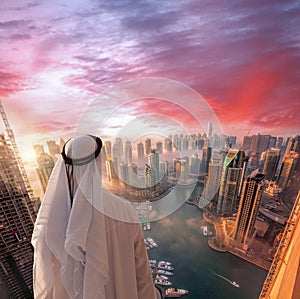 Arabian man is watching Dubai marina in Dubai, United Arab Emirates.