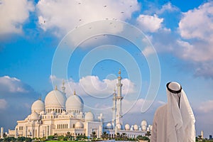 Arabian man watching Sheikh Zayed Grand Mosque in Abu-Dhabi, United Arab Emirates