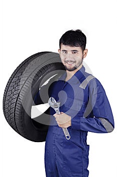 Arabian mechanic holds spanner and tire
