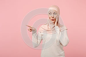 Arabian muslim girl in hijab light clothes posing isolated on pink background. People religious Islam lifestyle concept
