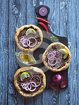 Arabian opened meat pies Sfiha on wooden board.