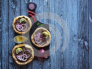 Arabian opened meat pies Sfiha on wooden board.