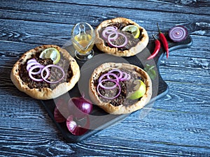 Arabian opened meat pies Sfiha on wooden board.