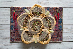 Arabian opened meat pies on white wood background.