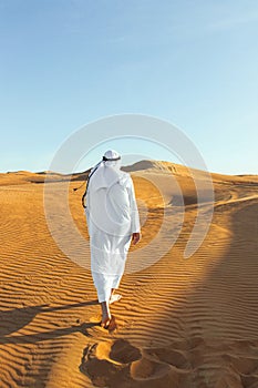 Arabian sheikh in long white dress closeup in the middle of Dubai desert