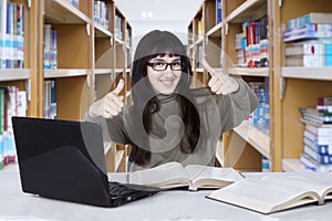 Arabian student showing thumbs up in the library