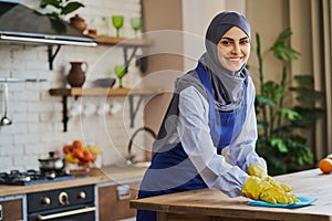 Arabian woman cleaning a table in the kitchen