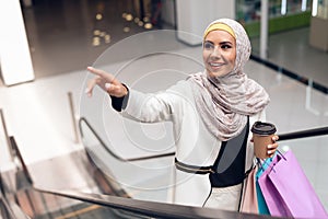 Arabian Woman with Cup of Coffee Standing in Mall.