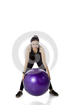 Arabian woman exercising with fitness ball on studio