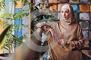 Arabian young muslim woman sitting in a cafe.