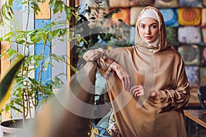 Arabian young muslim woman sitting in a cafe.