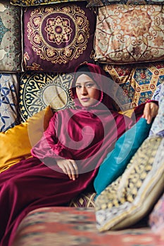 Arabian young muslim woman sitting in a cafe.