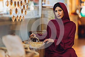 Arabian young muslim woman sitting in a cafe.