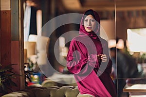 Arabian young muslim woman sitting in a cafe.