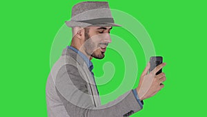 Arabic attractive man in casual clothes recording video for blog on a Green Screen, Chroma Key.