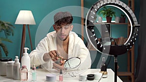 Arabic beauty male blogger applying face bubble mask filming daily skin care routine tutorial at camera. Influencer guy