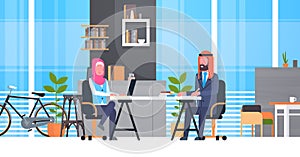 Arabic Business Man And Woman Sitting At Office Desk In Modern Coworking Space Working Together Muslim Workers In