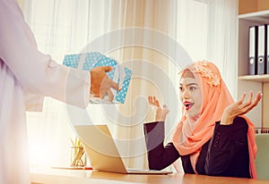 Arabic business muslim man gifting present to girlfriend at office, Romantic surprise concept