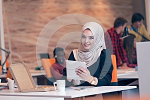 Arabic business woman wearing hijab, working in startup office.