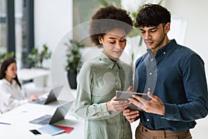 Arabic Businessman And African Colleague Using Digital Tablet In Office